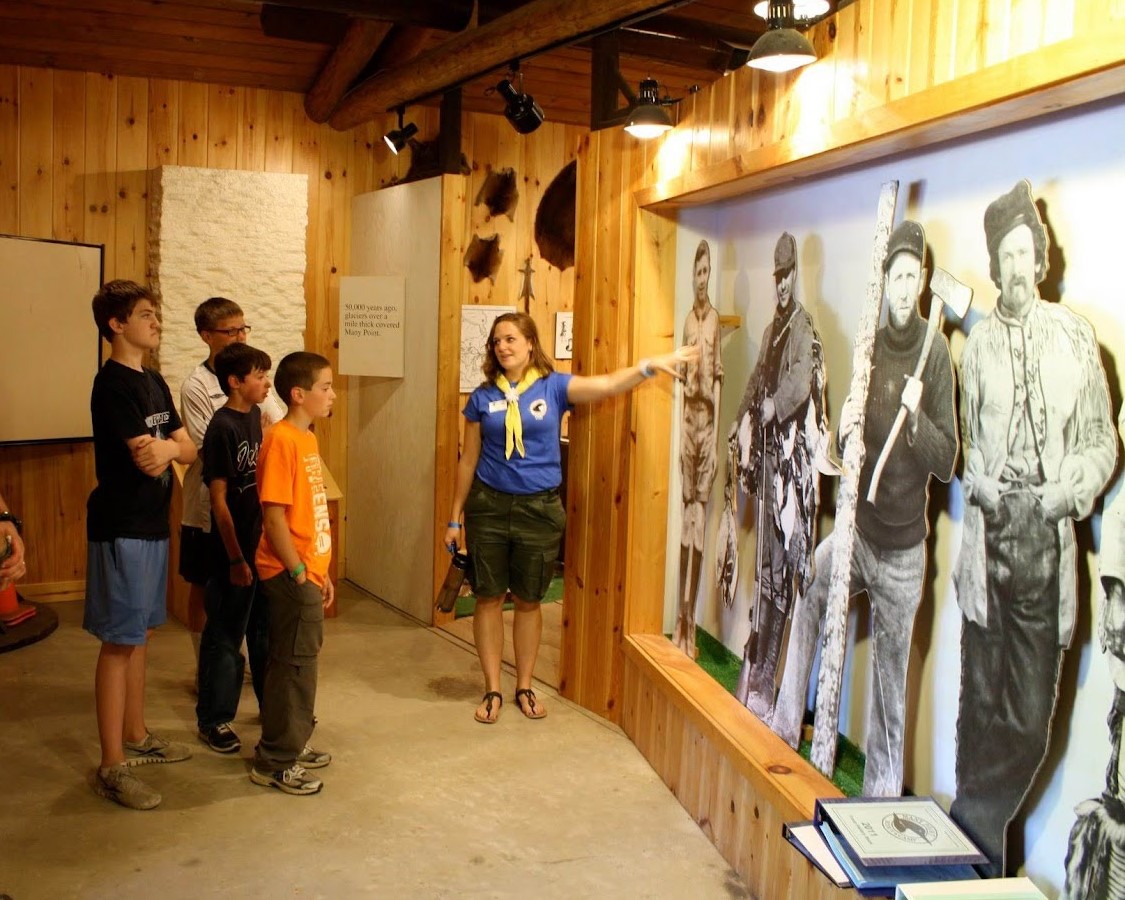 A staff member giving a history center tour to 3 Scouts and an adult leader